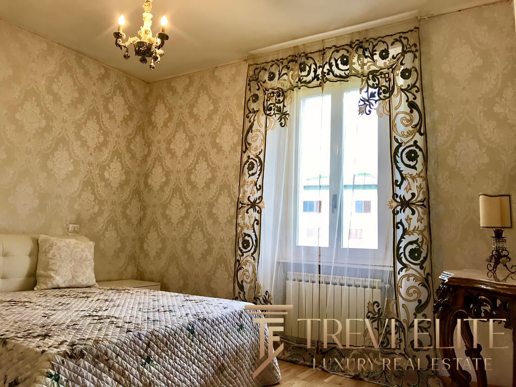 Элегантная спальня с богатым дизайном интерьера, украшенная изыскanym шторами и классической мебелью, светлая и уютная, идеально подходит для комфортного отдыха.