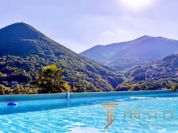 Вид на горы и природу с бассейна, окруженного зеленью, в роскошной недвижимости Треви Элит.