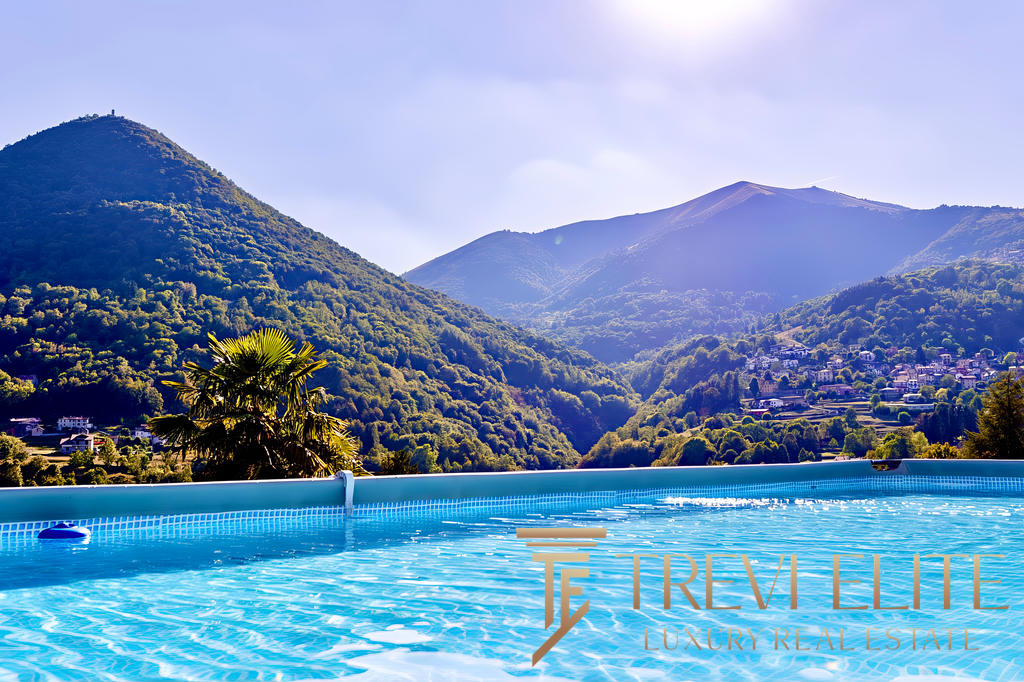 Вид на горы и природу с бассейна, окруженного зеленью, в роскошной недвижимости Треви Элит.
