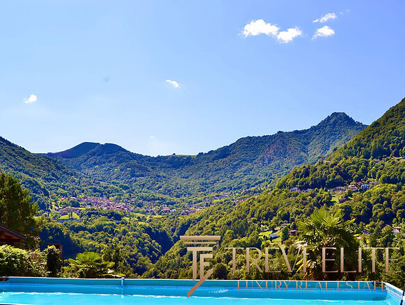 Роскошный вид на зелёные горы и живописные пейзажи с бассейном на переднем плане, идеальный для элитной недвижимости и отдыха на природе.