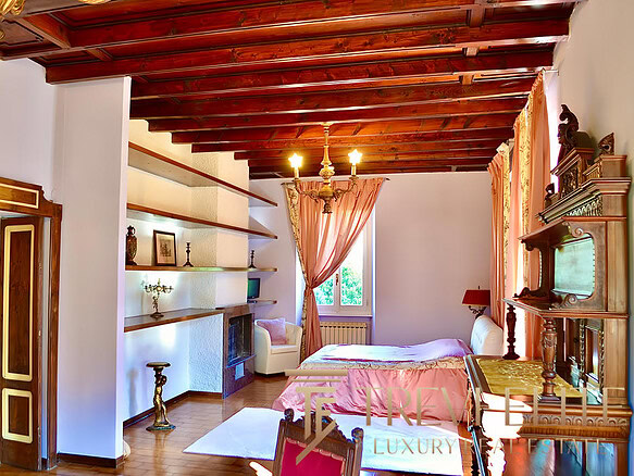 Загруженная фотография демонстрирует уютную и роскошную спальню с деревянным потолком, классической мебелью и мягким освещением в интерьере древнерусского стиля.