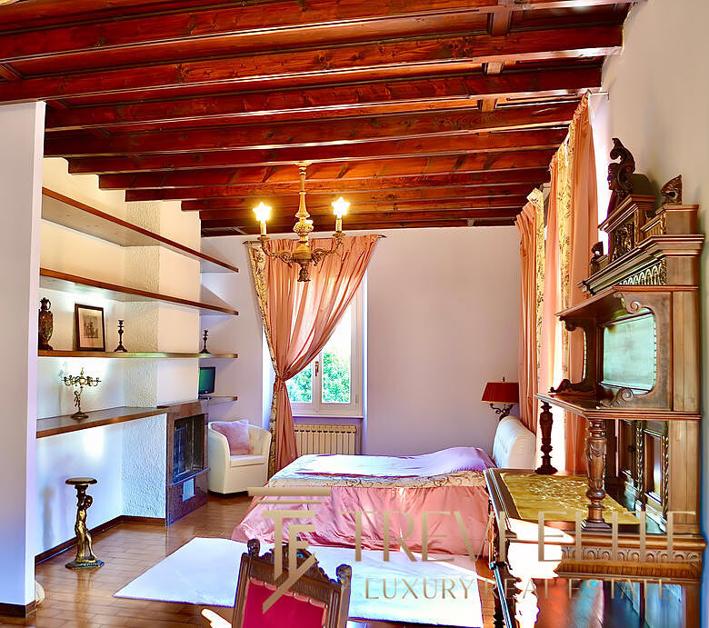 Загруженная фотография демонстрирует уютную и роскошную спальню с деревянным потолком, классической мебелью и мягким освещением в интерьере древнерусского стиля.