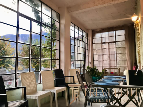 Современная зона отдыха в офисе или кафе с большими панорамными окнами и уютной атмосферой, идеальной для встреч и переговоров.