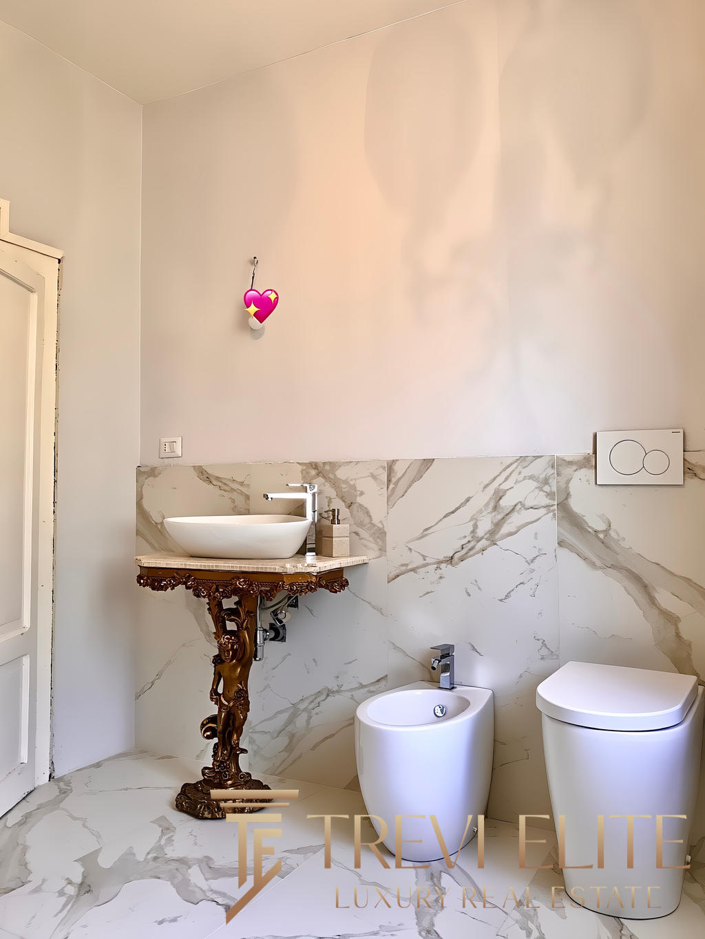 Мраморные стены и стильное дизайнерское биде в современной ванной комнате. Элегантное сочетание классики и модерна, создающее атмосферу роскоши и уюта в жилом помещении.
