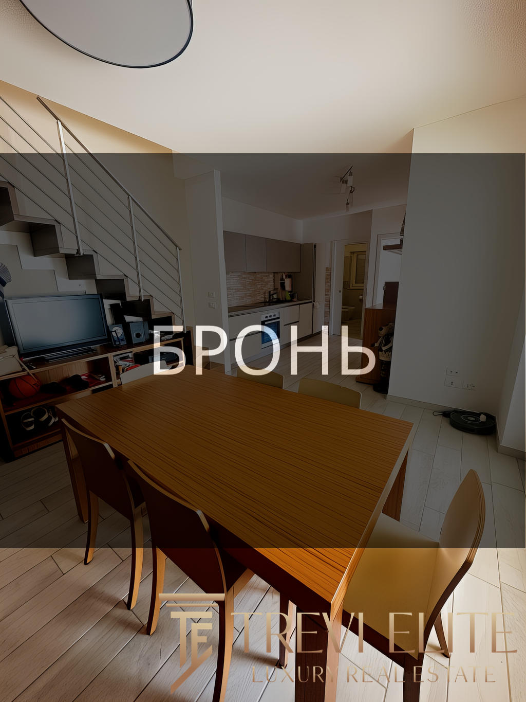 Высококачественное изображение современной жилой квартиры с уютной обеденной зоной и кухней в стиле лофт, подходящей для элитной недвижимости или аренды.