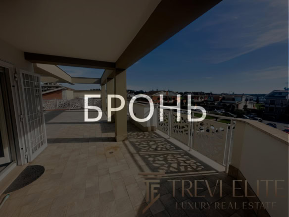 Современная просторная крытая терраса на верхнем этаже жилого комплекса, с панорамным видом на город, идеально подходит для отдыха и развлечений.