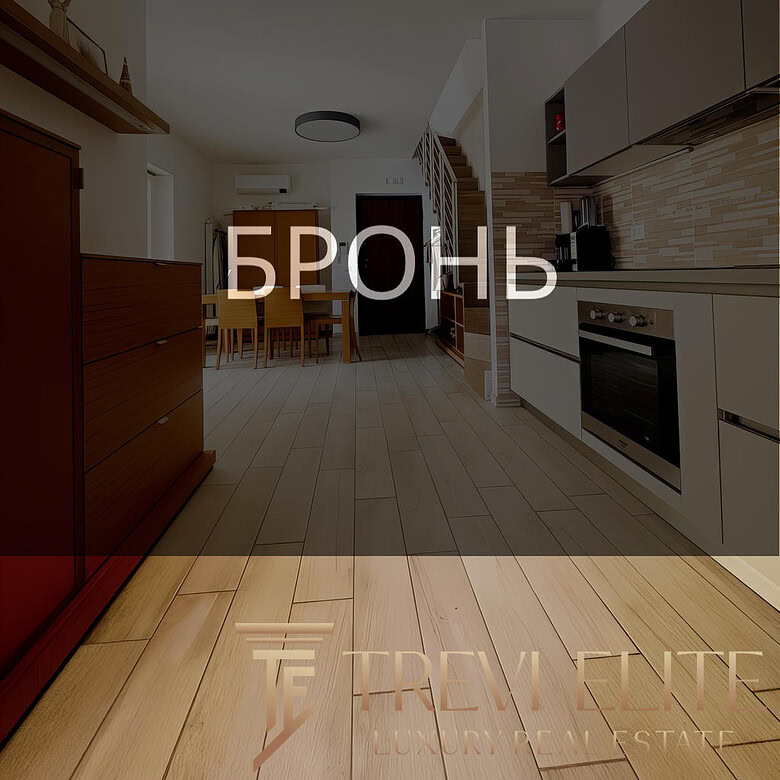 Комнатное интерьерное изображение современной кухни с деревянными полами и встроенной техникой, идеальное оформление для презентации элитной недвижимости от Треви Элит.