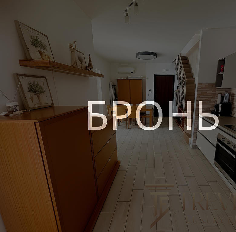 Кухонная зона с современной техникой и аккуратной отделкой, светлый интерьер, просторное помещение в жилом доме, дизайн квартиры для комфортного проживания.