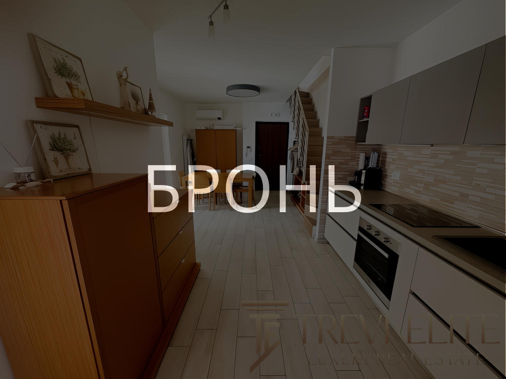 Кухонная зона с современной техникой и аккуратной отделкой, светлый интерьер, просторное помещение в жилом доме, дизайн квартиры для комфортного проживания.