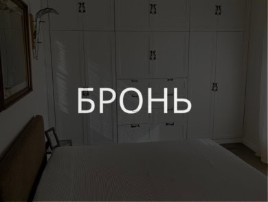 Роскошная спальня с встроенными белыми шкафами, уютной кроватью и стильными декорациями, создающими атмосферу комфорта и современного дизайна в элитной недвижимости.