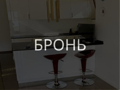 Бронзовые барные стулья у кухонной стойки в современном интерьере квартиры.