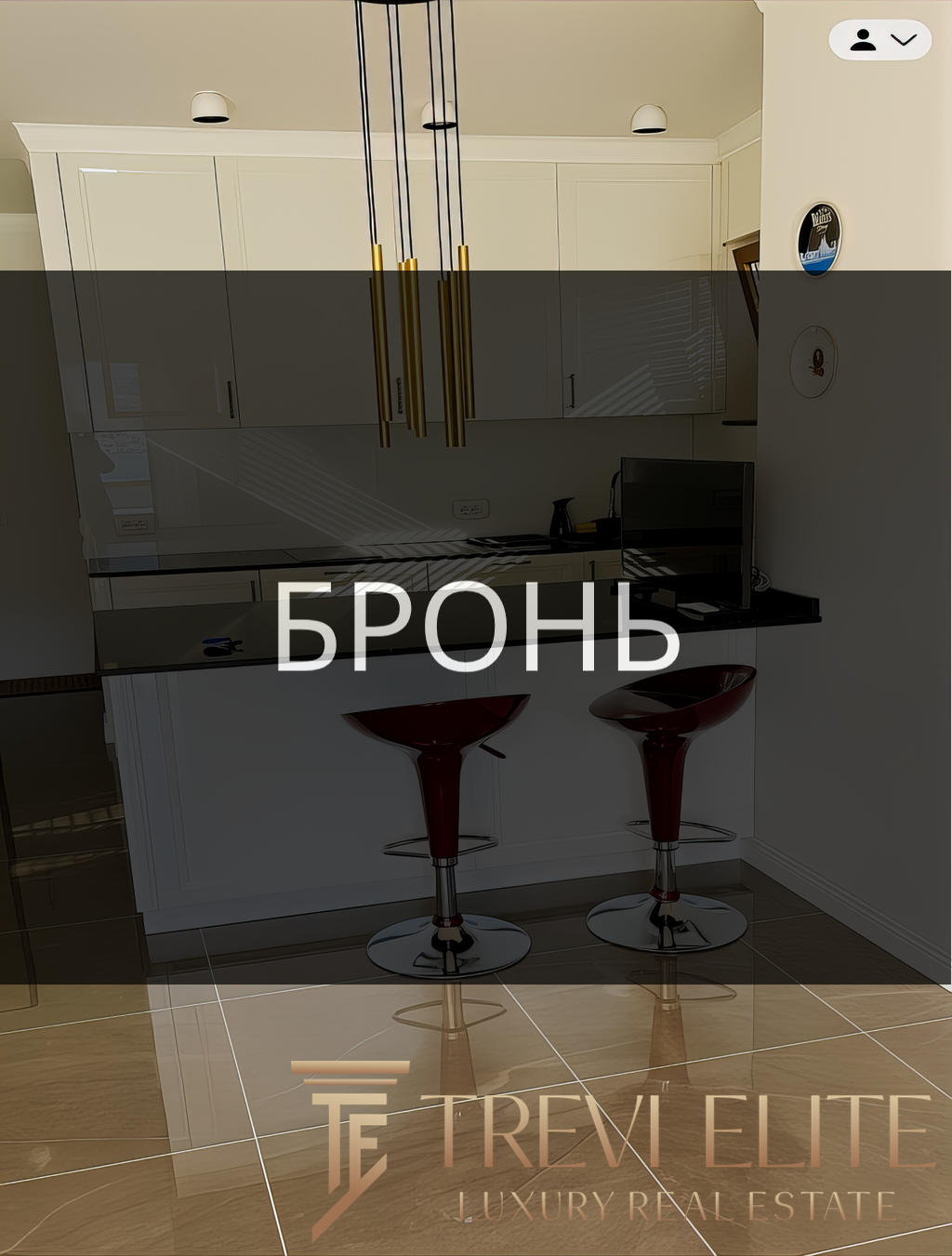 Бронзовые барные стулья у кухонной стойки в современном интерьере квартиры.