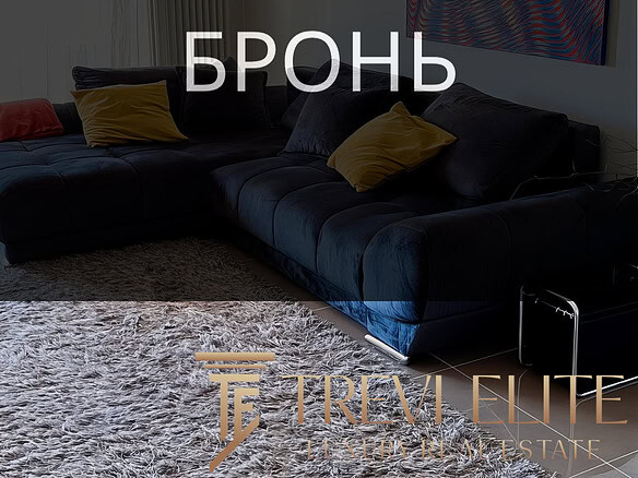 Высокотехнологичный дизайн гостиной с современной мебелью и ярким абстрактным искусством на стене. Просторное и уютное помещение с мягким ковром и стильными подушками.