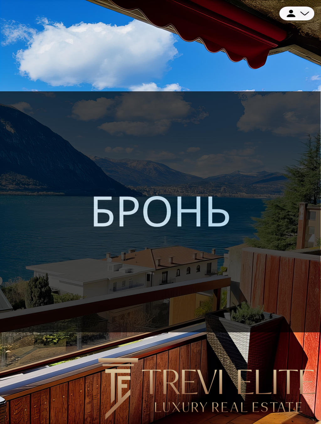 вид на озеро и горы с балкона с деревянным настилом, уютной мебелью и цветущими растениями, панорамный вид на природу и спокойствие, фото демонстрирует роскошные апартаменты у воды, агентство недвижимости Треви Элит.