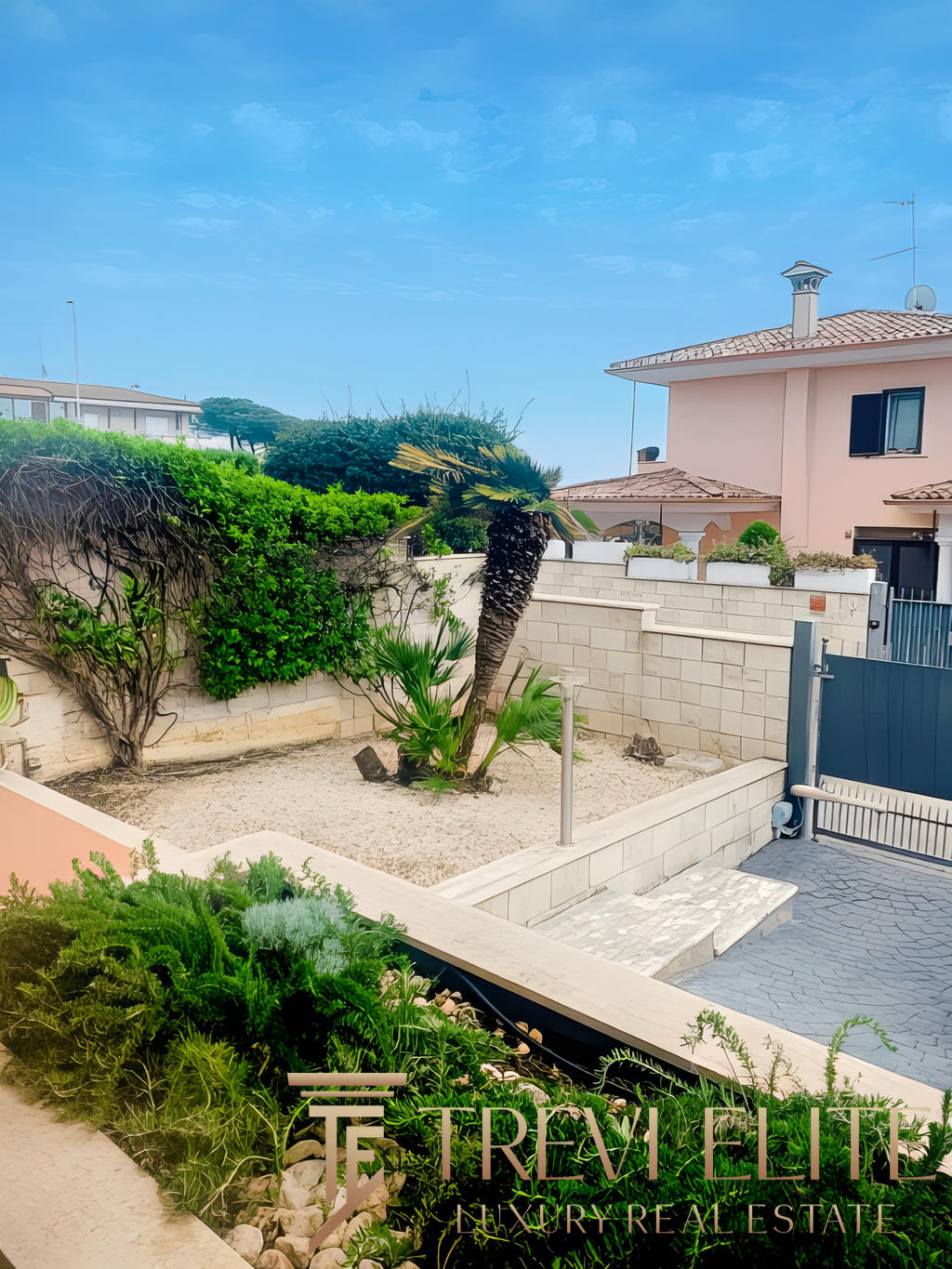 Улица с ухоженным садом и пальмами рядом с частным домом в солнечную погоду.