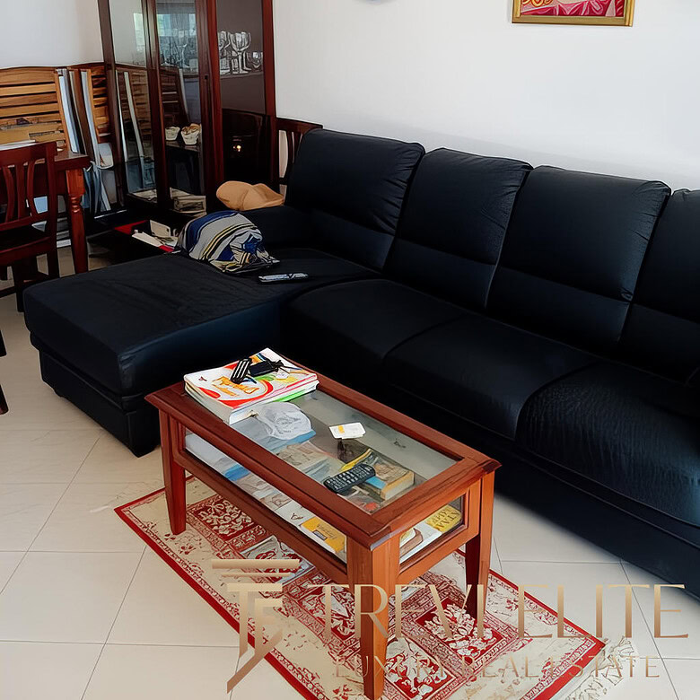 2. Люксовая гостиная с черным кожаным диваном, деревянной мебелью, украшенная национальными ремеслами и картинами в классическом стиле.