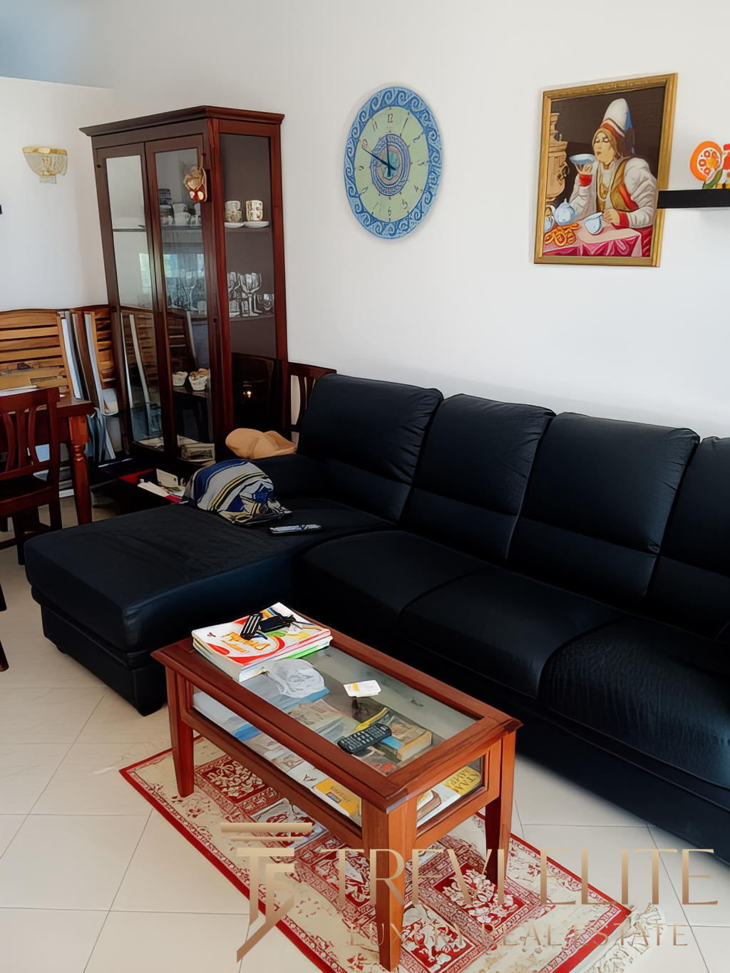 2. Люксовая гостиная с черным кожаным диваном, деревянной мебелью, украшенная национальными ремеслами и картинами в классическом стиле.