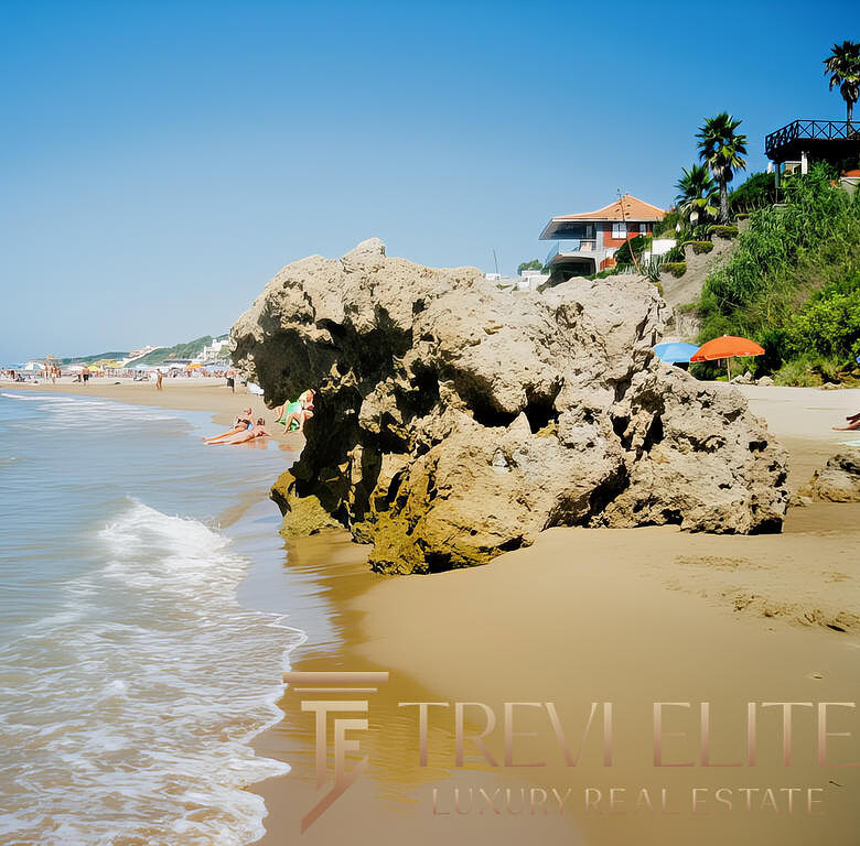 Пляж с крупными камнями, голубое море и солнечная погода, отдыхающие и облачка на фоне современных домов на холме, геотуризм и отдых у моря,эксклюзивная недвижимость на берегу, премиальный отдых в курорте.