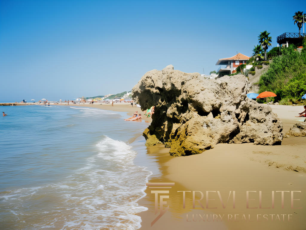 Пляж с крупными камнями, голубое море и солнечная погода, отдыхающие и облачка на фоне современных домов на холме, геотуризм и отдых у моря,эксклюзивная недвижимость на берегу, премиальный отдых в курорте.
