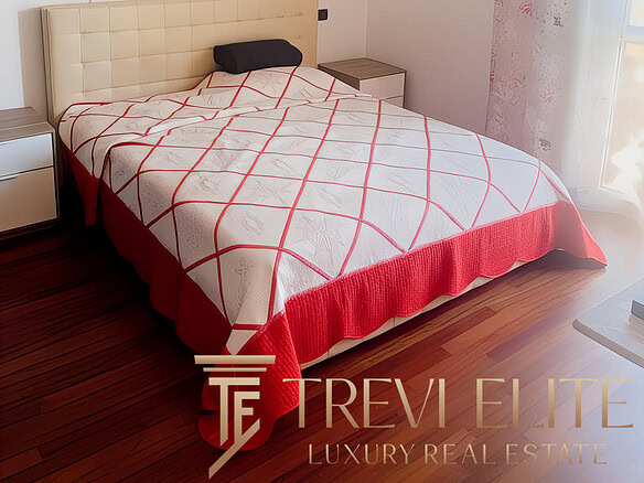 Современная спальня с уютным кроватью, светлыми стенами, ярким постельным бельем и идеальным освещением, украшенная картинами и эффектными светильниками.