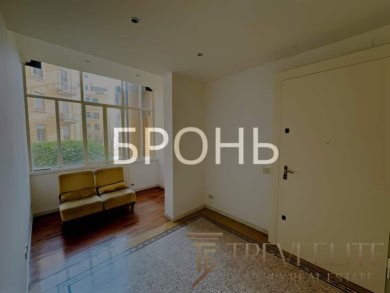 Окно с видом на жилой комплекс и уютный жёлтый диван в светлой гостиной.