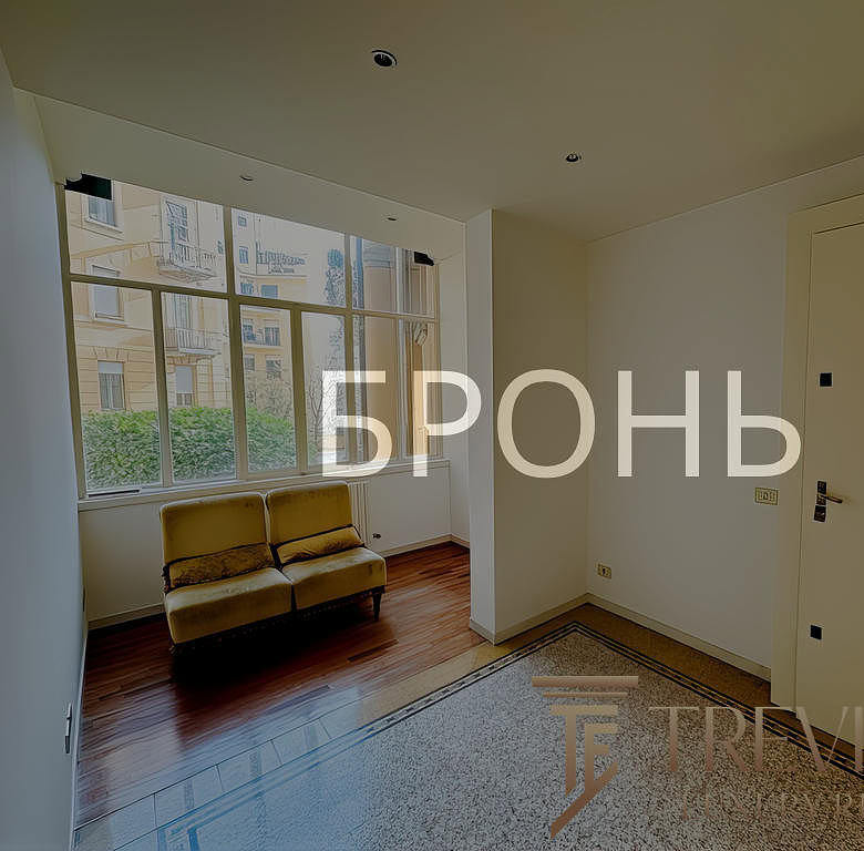 Окно с видом на жилой комплекс и уютный жёлтый диван в светлой гостиной.