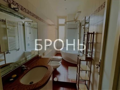 Оригинальный дизайн ванной комнаты в элитной недвижимости с современной сантехникой и стильным кафелем. Просторная ванная и красивые аксессуары создают уют и роскошь.