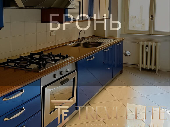 Газовая плита, синие кухонные шкафы и окно с видом на улицу в современной кухне. Просторная и светлая кухня с удобным дизайном, идеально подходит для комфортного проживания.