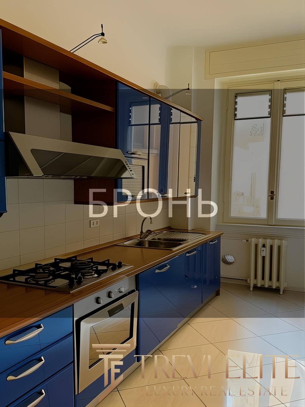 Газовая плита, синие кухонные шкафы и окно с видом на улицу в современной кухне. Просторная и светлая кухня с удобным дизайном, идеально подходит для комфортного проживания.