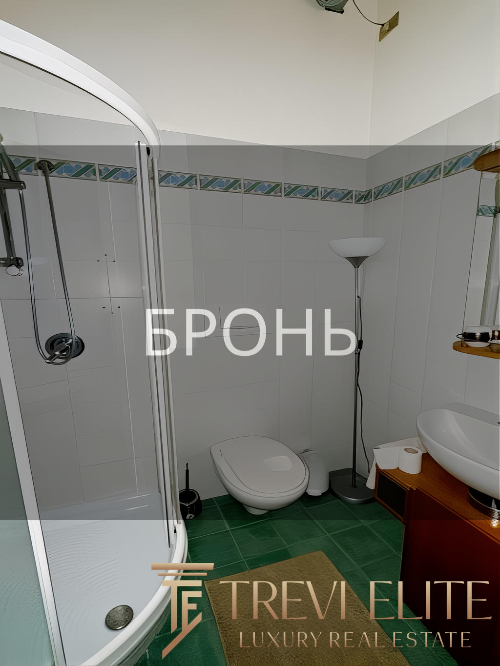 солнечный интерьер ванной комнаты с душевой кабиной, унитазом и раковиной, зеленым полом и декоративной плиткой, современное уютное пространство в частном доме, комфортное жилье.