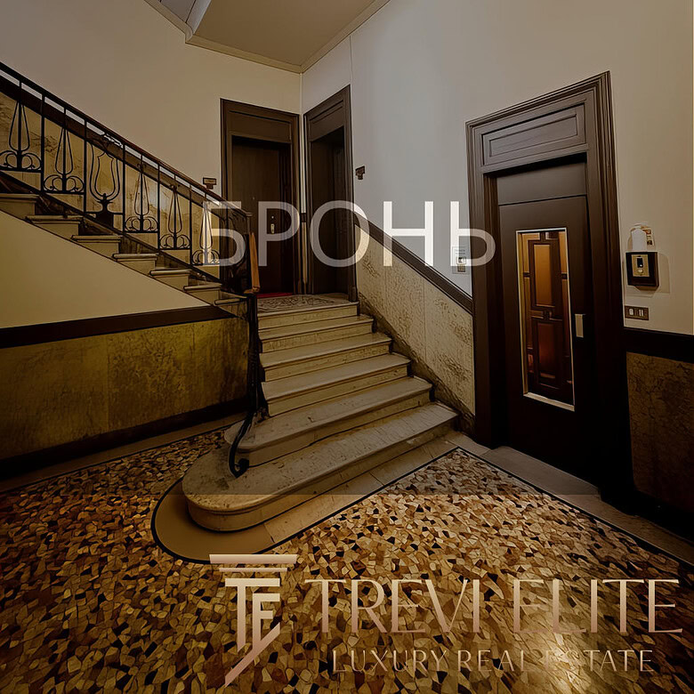 Высокий этаж жилого дома с элегантной лестницей, мраморными ступенями и художественной отделкой стен в классическом стиле. Идеальное пространство для проживания или аренды с уютной атмосферой и продуманной планировкой.