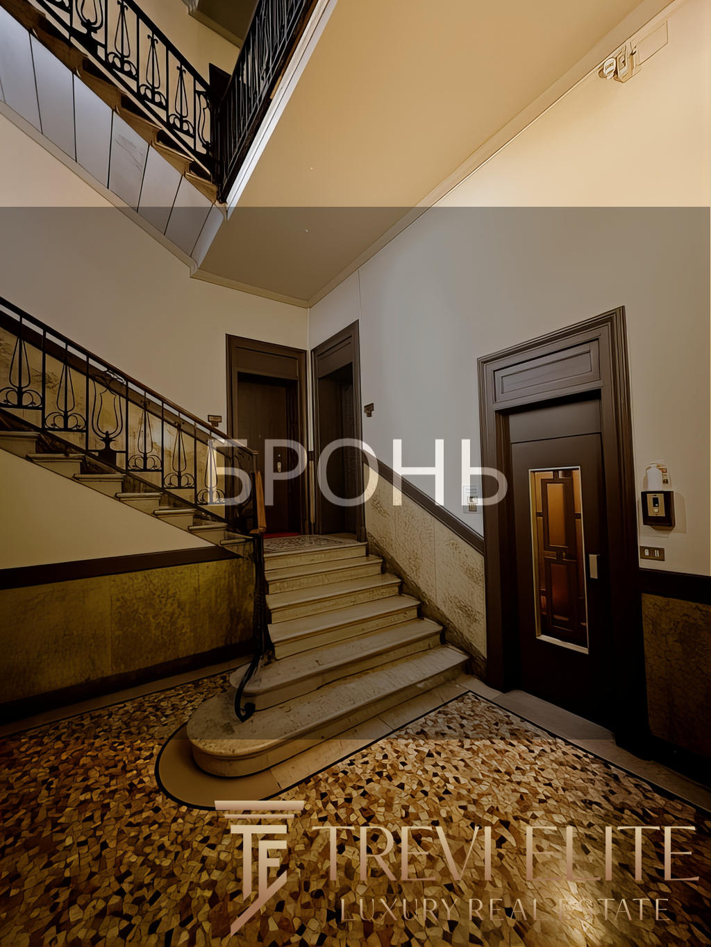 Высокий этаж жилого дома с элегантной лестницей, мраморными ступенями и художественной отделкой стен в классическом стиле. Идеальное пространство для проживания или аренды с уютной атмосферой и продуманной планировкой.