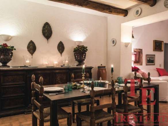 Уютная столовая в доме с антикварной мебелью и уютным интерьером, свечами и декоративными аксессуарами, создающая теплую атмосферу для семейных ужинов и встречи гостей.