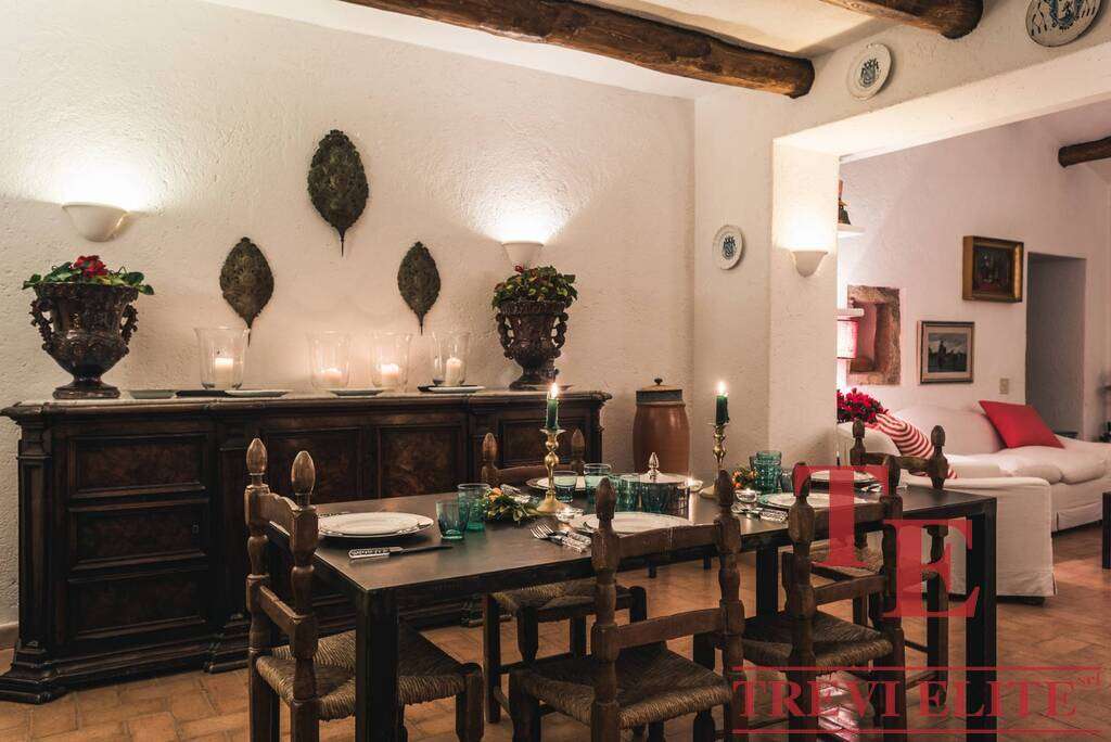 Уютная столовая в доме с антикварной мебелью и уютным интерьером, свечами и декоративными аксессуарами, создающая теплую атмосферу для семейных ужинов и встречи гостей.