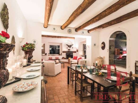 Роскошный интерьер загородного дома с белыми стенами, деревянными балками и уютной обстановкой для элитной недвижимости.