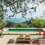 Роскошный бассейн на природе с видом на море, окруженный зеленью и уютной зоной отдыха в эксклюзивной недвижимости Треви Элит.