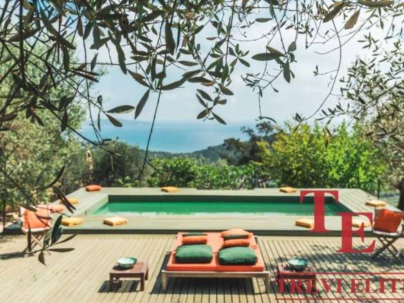 Роскошный бассейн на природе с видом на море, окруженный зеленью и уютной зоной отдыха в эксклюзивной недвижимости Треви Элит.