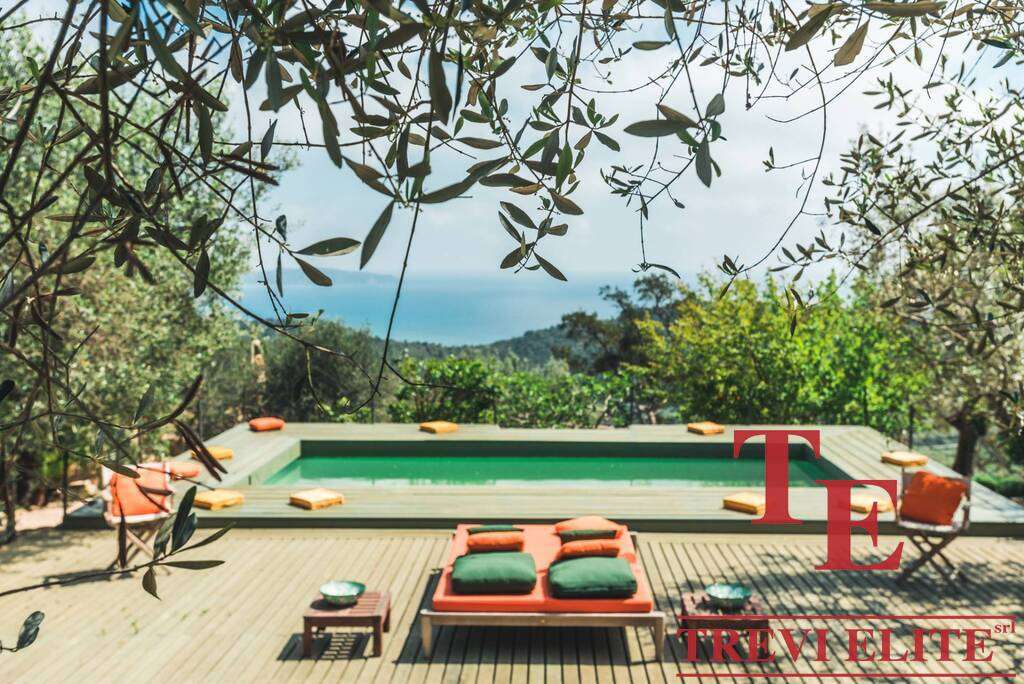 Роскошный бассейн на природе с видом на море, окруженный зеленью и уютной зоной отдыха в эксклюзивной недвижимости Треви Элит.