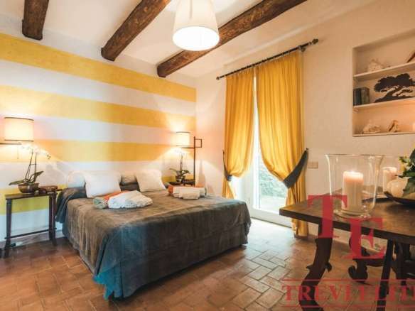 Современная уютная спальня с яркими желтыми шторами и деревянным потолком, создающая теплую атмосферу для отдыха и комфорта.