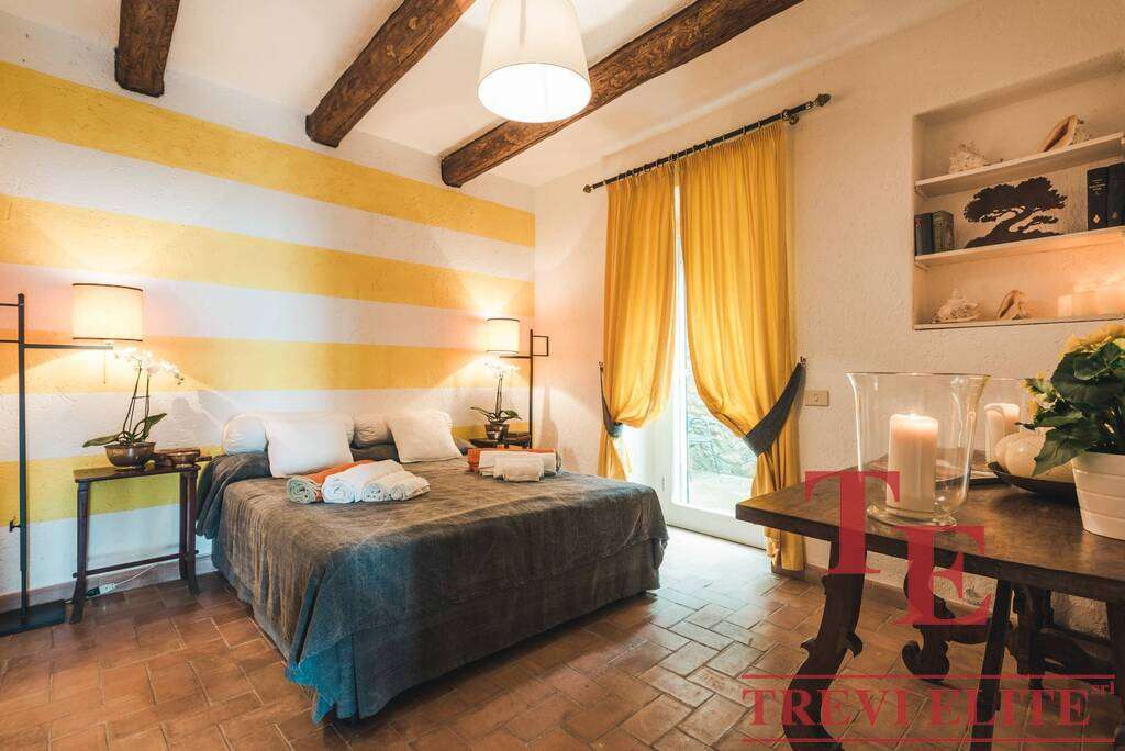 Современная уютная спальня с яркими желтыми шторами и деревянным потолком, создающая теплую атмосферу для отдыха и комфорта.