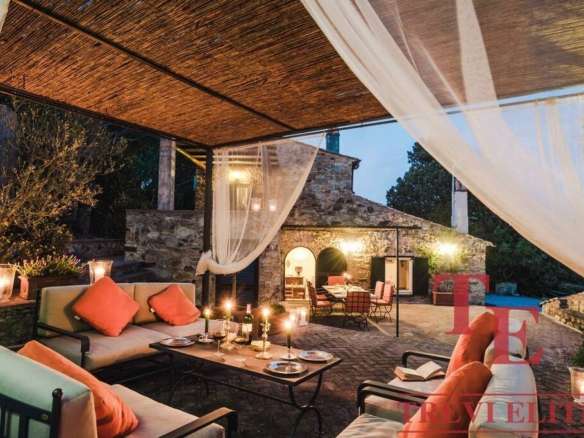 Роскошная открытая терраса с уютной мебелью и свечами, ночная подсветка, стильный дизайн, идеальный для вечерних мероприятий и отдыха на загородной вилле.
