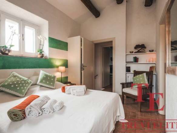 Элитная спальня в роскошной итальянской недвижимости, уютная и стильная, с зелеными акцентами, мягкой мебелью и современным декором, идеально подходит для комфортного проживания.
