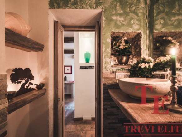 Роскошная интерьерная ванная комната с современным дизайном, элегантной раковиной и цветочными композициями, создающий уют и стиль высокой элитной недвижимости.