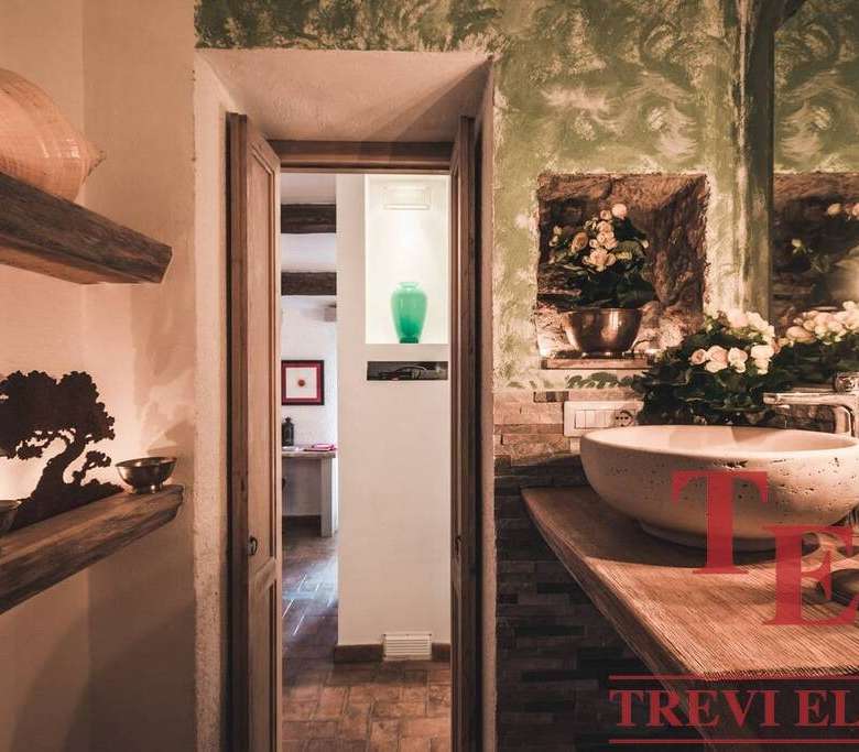 Роскошная интерьерная ванная комната с современным дизайном, элегантной раковиной и цветочными композициями, создающий уют и стиль высокой элитной недвижимости.