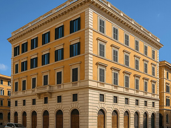 Элитное здание в классическом стиле на солнечной улице с ярко-голубым небом на заднем плане.