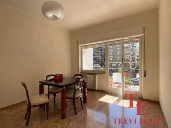 Современная квартира с большим балконом и видом на город, светлая гостиная зона, деревянная мебель в стиле классика, от агентства недвижимости Треви Элит.