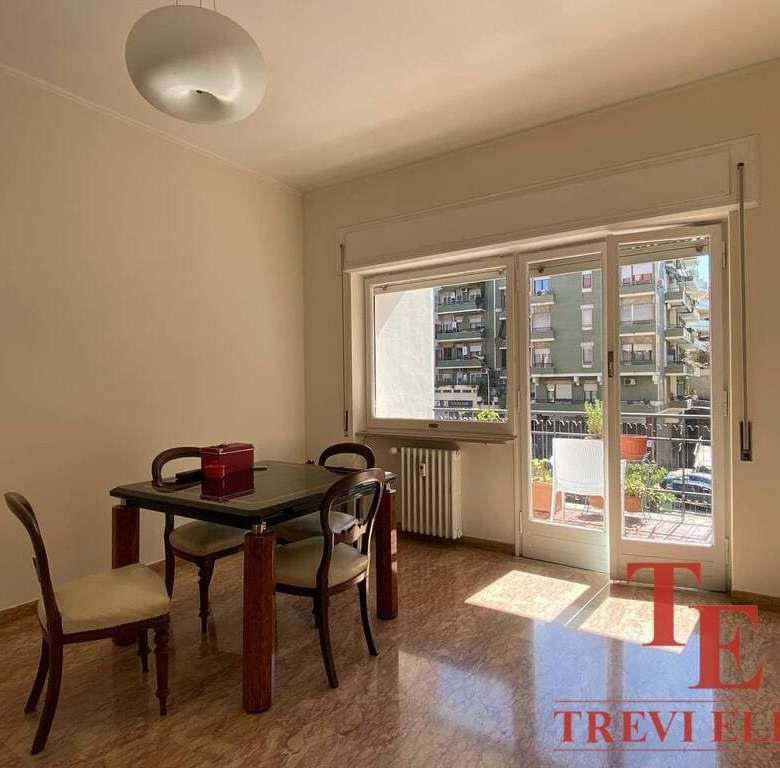 Современная квартира с большим балконом и видом на город, светлая гостиная зона, деревянная мебель в стиле классика, от агентства недвижимости Треви Элит.