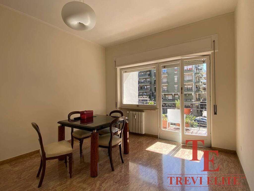 Современная квартира с большим балконом и видом на город, светлая гостиная зона, деревянная мебель в стиле классика, от агентства недвижимости Треви Элит.