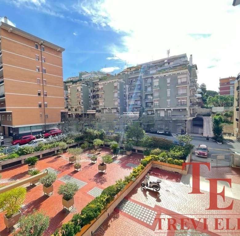 Уютный двор с зеленой зоной и пешеходной дорожкой в жилом комплексе, окруженном современными многоэтажками в центре города.