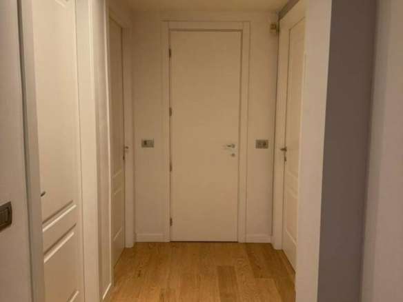 Элегантная прихожая с белыми стенами и деревянным полом в роскошном доме, созданная для высокого стиля и комфорта.